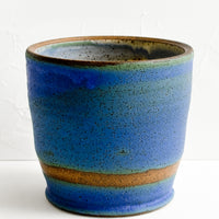 Borealis Blue: A ceramic utensil holder in white speckle.A ceramic utensil holder in borealis blue/green glaze.
