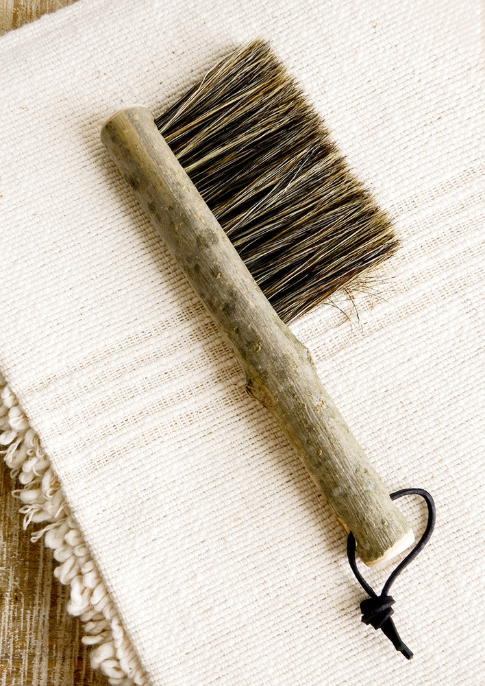 3: Bristle brush with natural bark handle and leather tie at end