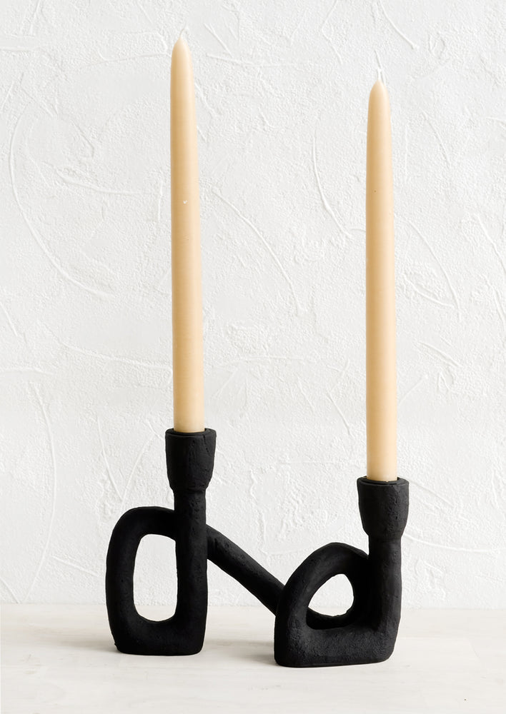 2: An asymmetrical taper holder in curved design, showing two taper candles.