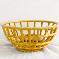 3: An open weave bowl made from mustard-colored ceramic.