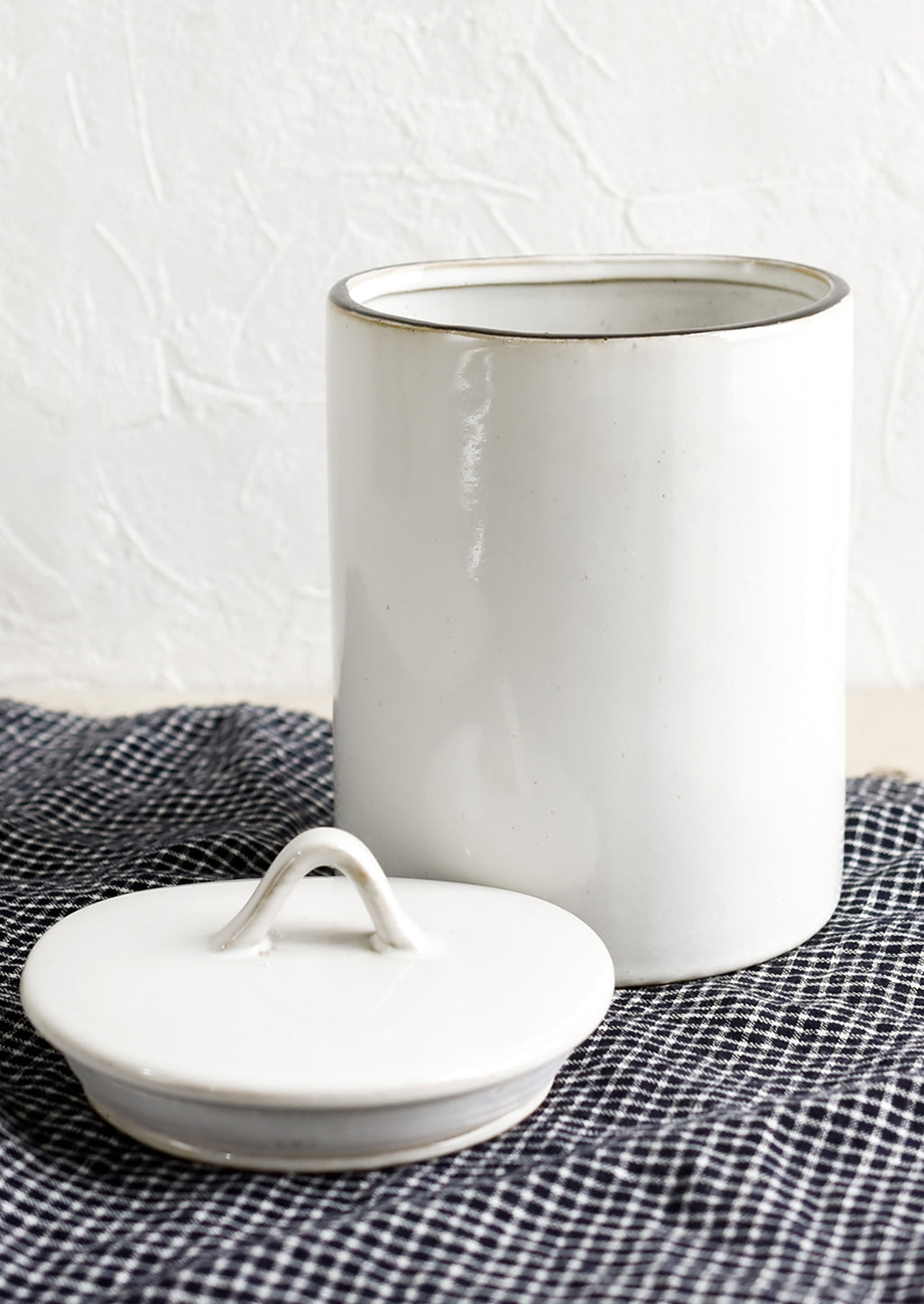 2: A tall, cylindrical ceramic storage jar in glossy white glaze with removable lid.