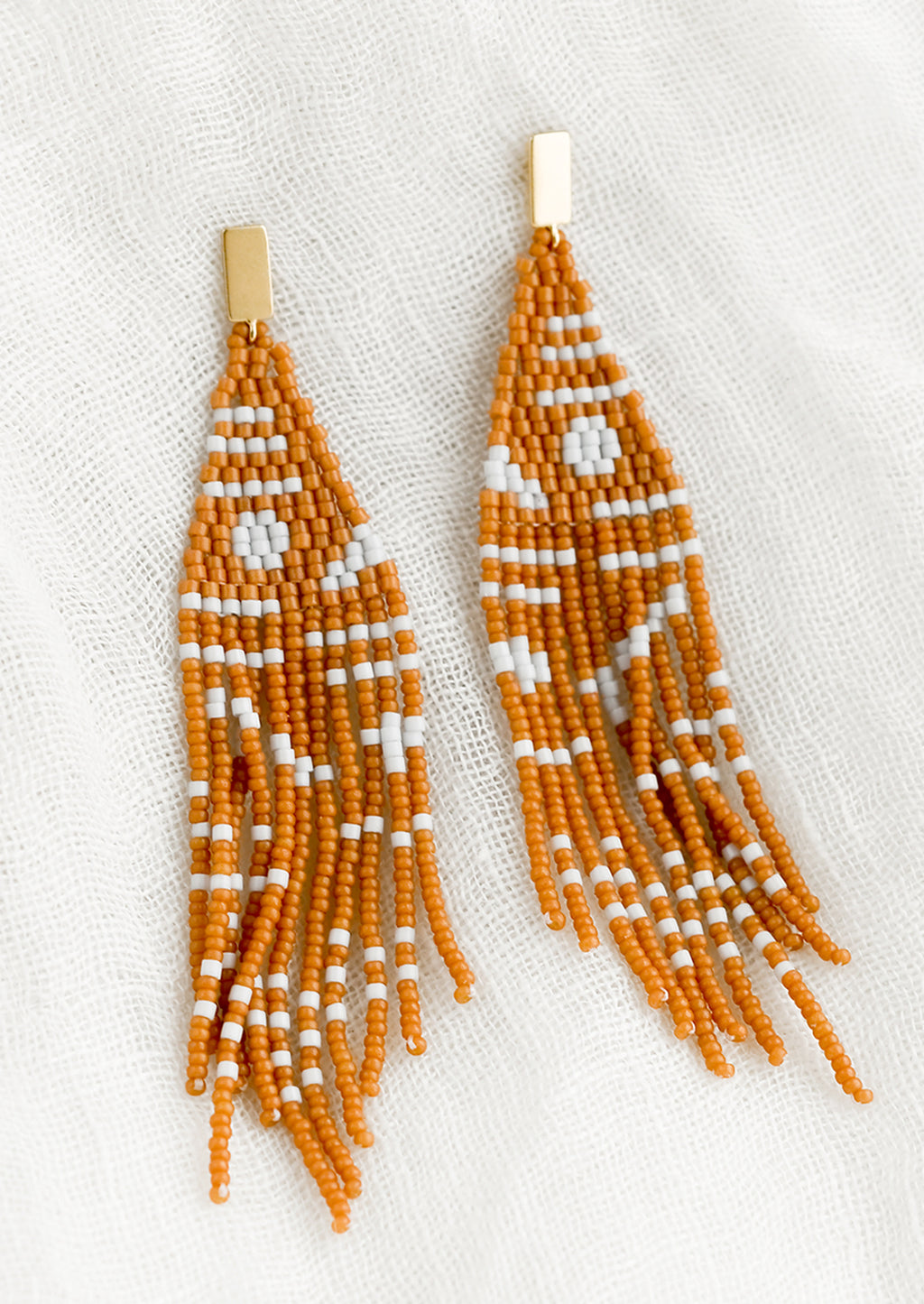 Cedar Multi: A pair of beaded earrings with geometric pattern in cedar and white.