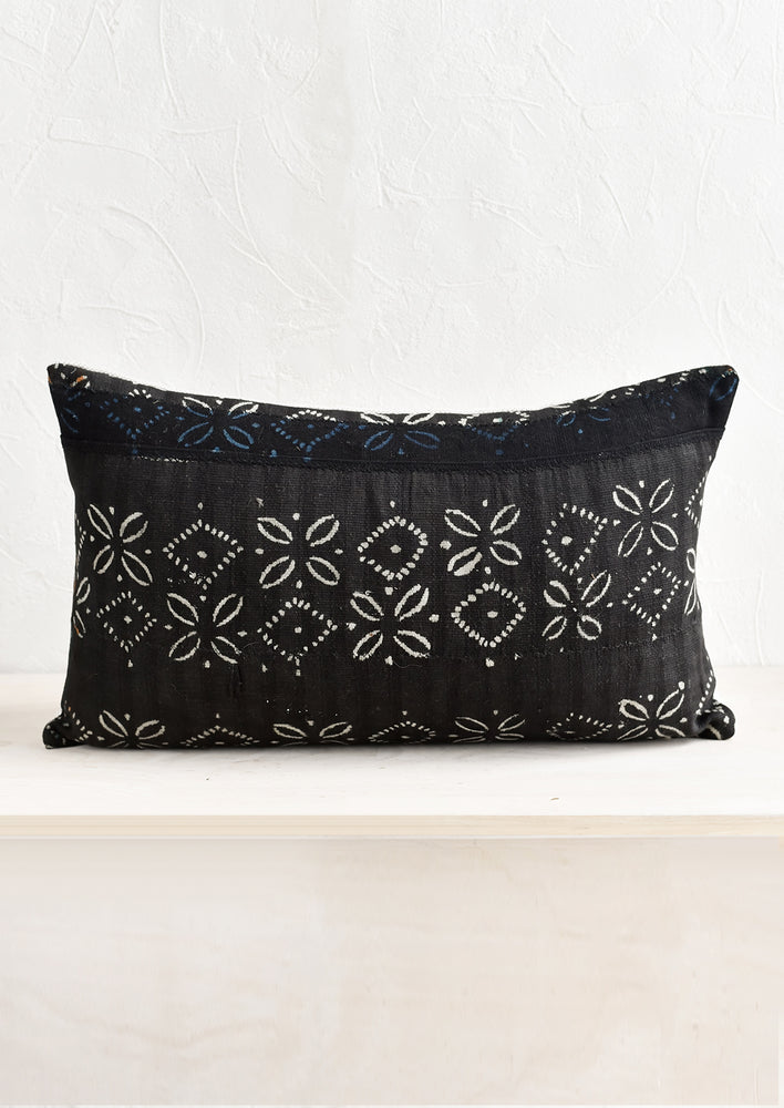 A lumbar pillow made from black strip cloth fabric.