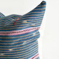 4: Indigo baule fabric pillow with thin orange and thicker pink stripes and small embroidered details