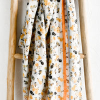 1: A floral print scarf with orange and blue border.