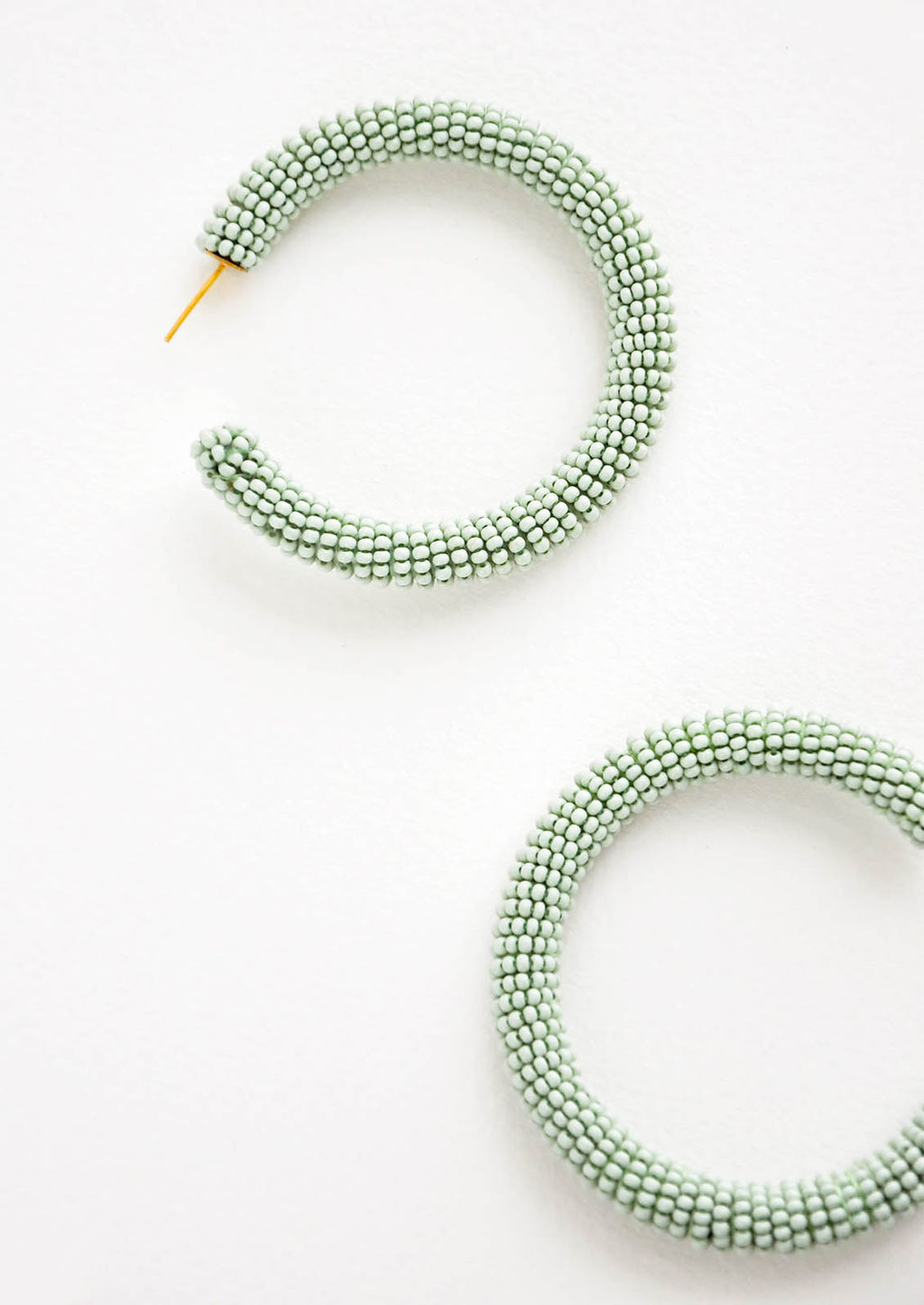 Mint: Thick hoop earrings of mint green colored glass beads.