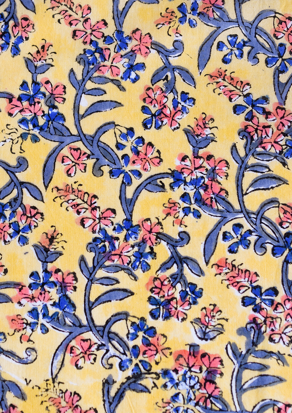 4: A block printed throw pillow in yellow with blue and pink floral print.