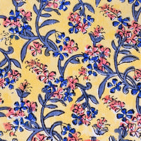 4: A block printed throw pillow in yellow with blue and pink floral print.