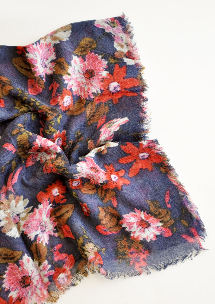 2: Close up shot of scarf with dark blue background and multi-colored pink and red floral pattern 