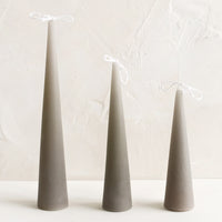 Small / Concrete: Three cone-shaped taper candles in light grey.
