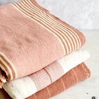 3: Stack of naturally colored cotton throws in pink, cream and terracotta