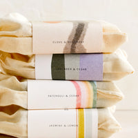 2: A stack of bar soaps in labeled muslin pouches.