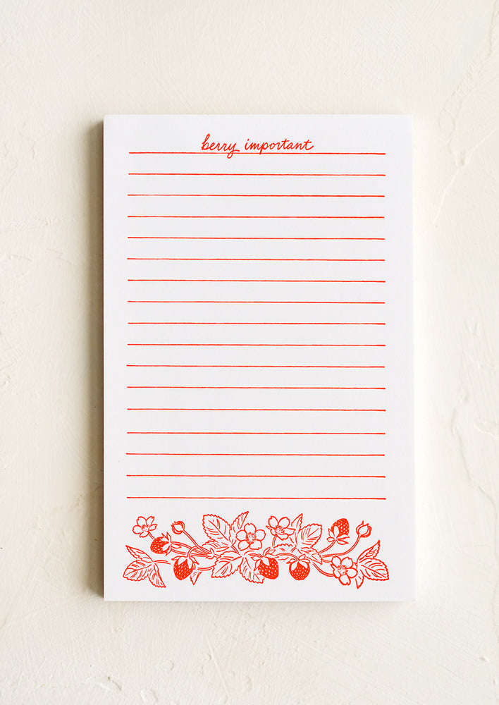 A white letterpress printed notepad with red lines and berry print.