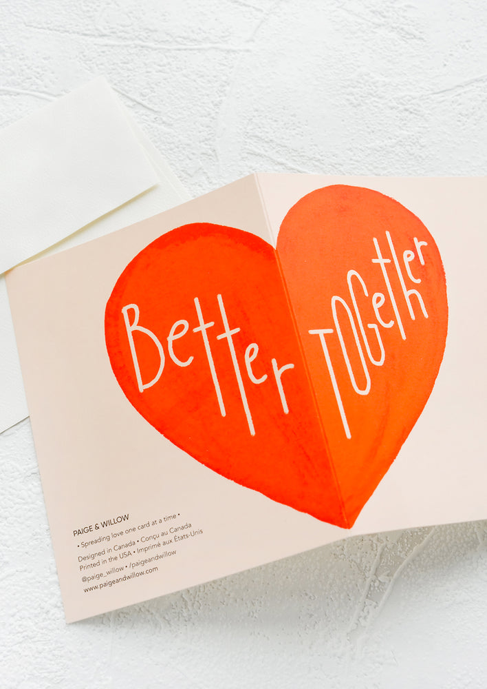 2: A greeting card with large red heart printed across card fold, reading "Better together".