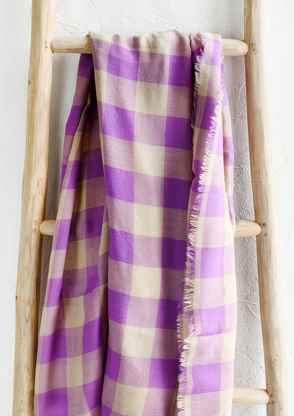 1: A gingham print scarf in purple and tan.