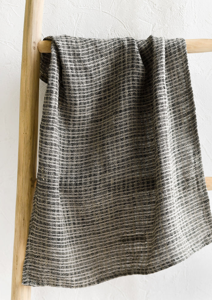 A linen tea towel in black and grey mini check print.