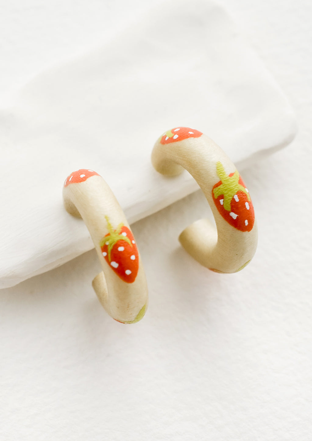 Strawberry: A pair of painted wood hoop earrings with strawberry pattern.