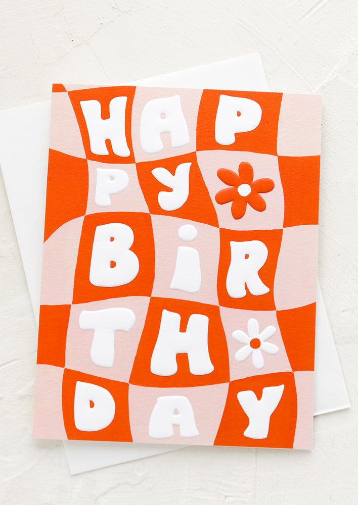 A pink and red checkered card reading "Happy birthday".