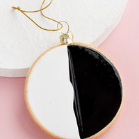 1: A decorative holiday ornament in the shape of a black & white cookie.