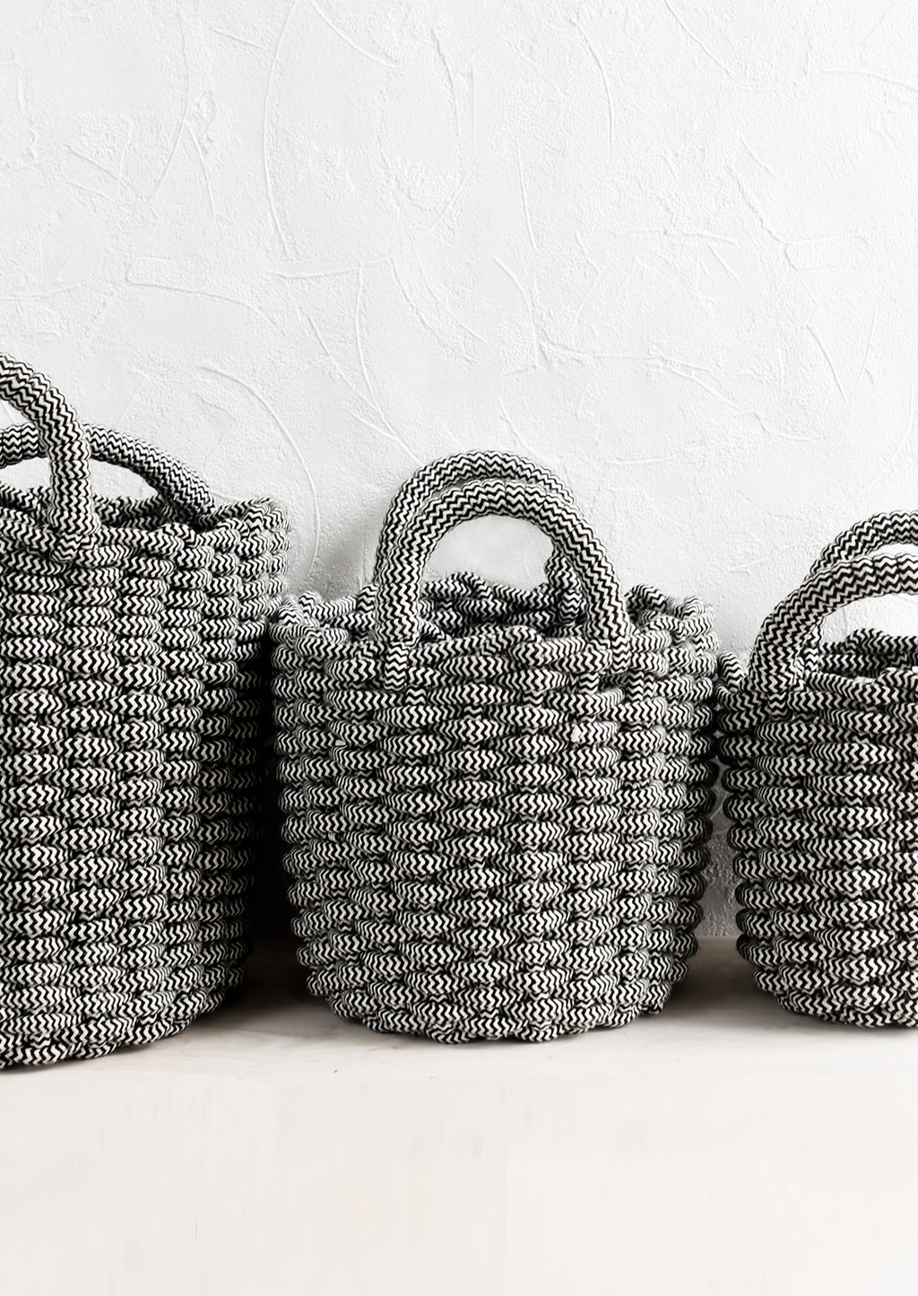 2: Black and white woven rope baskets in three incremental sizes.