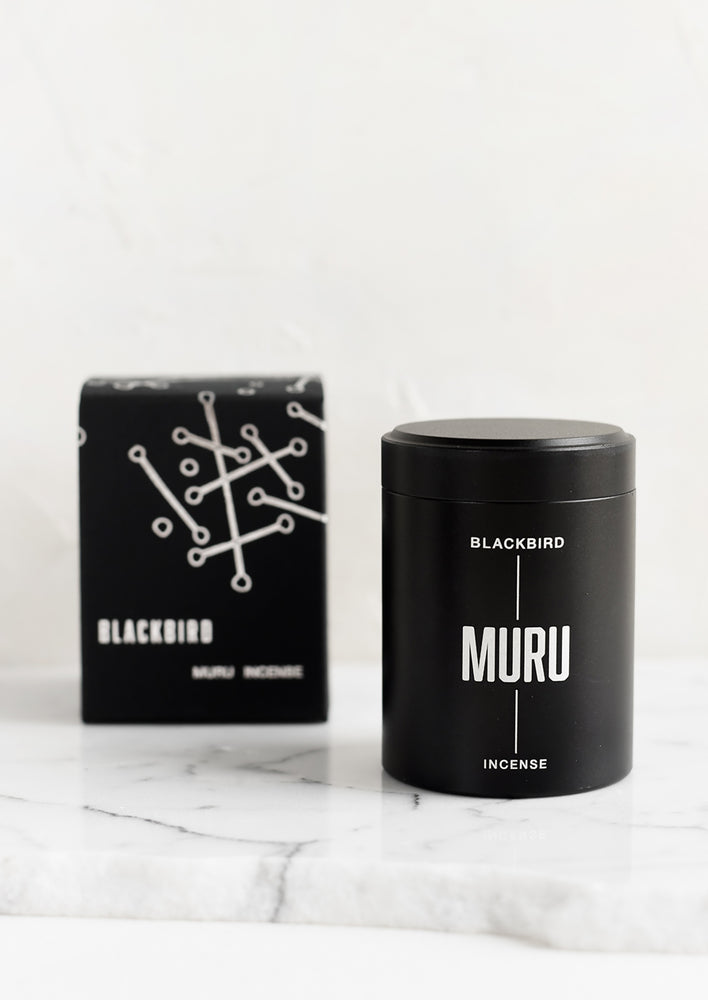 A black incense tin with black and silver packaging.