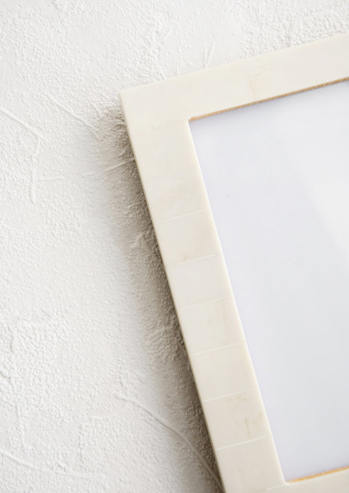 Picture frame with pale ivory resin border.
