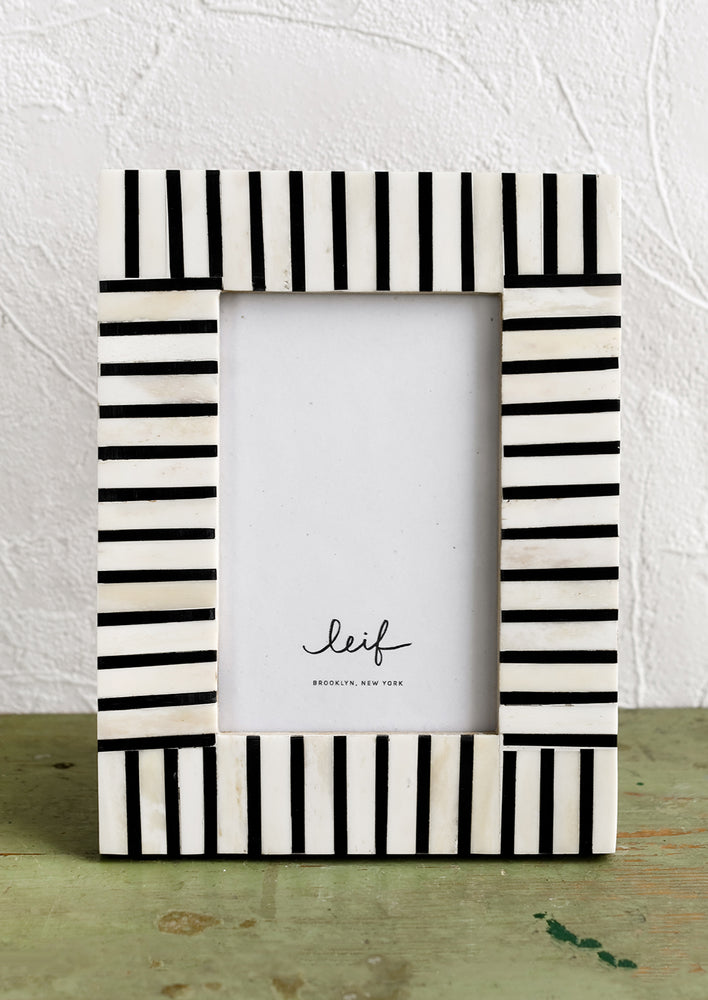 1: A black and white picture frame with alternating stripe pattern.