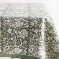 3: A block print tablecloth in ivy green with white and black floral print.