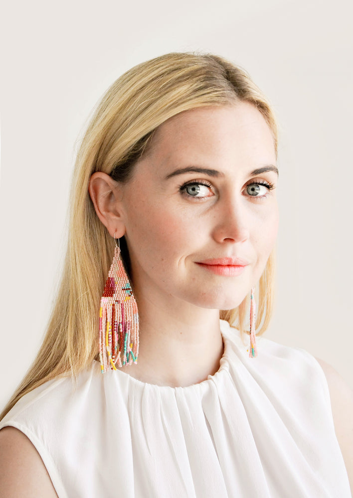 2: Model wears multicolored fringe beaded earrings and white blouse.