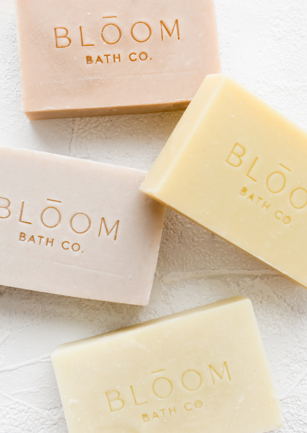 1: Four rectangular bars of soap in pastel colors with logo imprint.