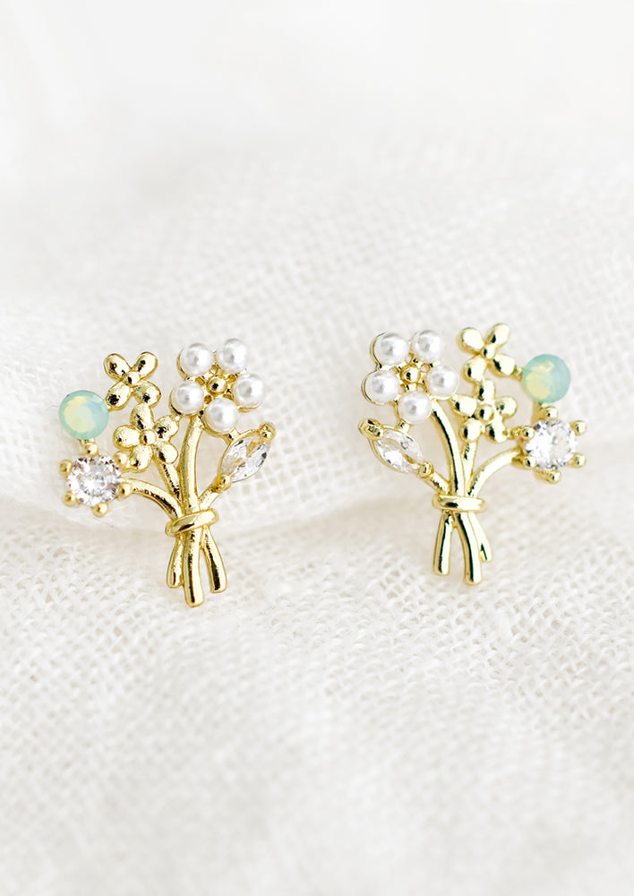 A pair of gold earrings in shape of flower bouquet.