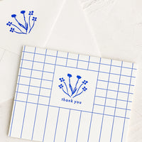 Single Card: A blue and white grid patterned thank you card with drawn floral imagery.