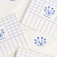 Boxed Set of 6: A set of blue and white grid patterned thank you cards with drawn floral imagery.