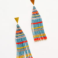 Lagoon Multi: Fringe beaded earrings in blue with yellow, orange, and gold horizontal stripes on a triangular gold post.