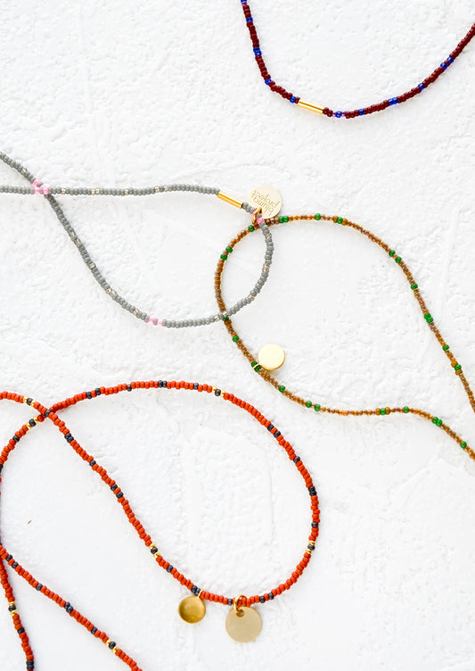 An assortment of choker necklaces made from multicolored seed beads