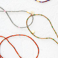 1: An assortment of choker necklaces made from multicolored seed beads