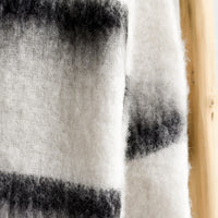 2: A fuzzy throw blanket in white with black stripes.