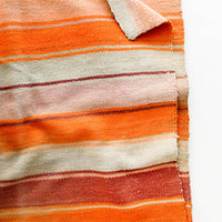 3: Woven textile intended for use as a rug or blanket, variegated colorful striped pattern.