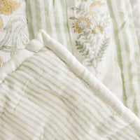 2: A quilt with botanical print on one side and stripe on back.