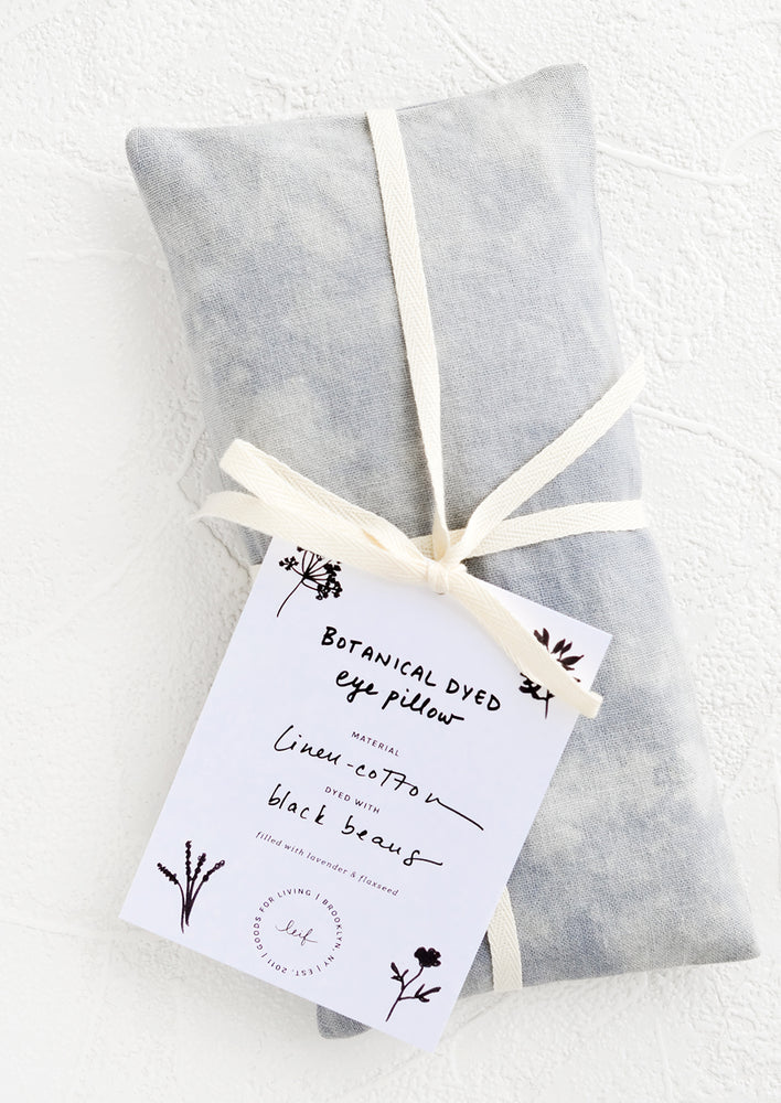 A naturally dyed relaxation eye pillow in blue-grey color dyed using black beans.