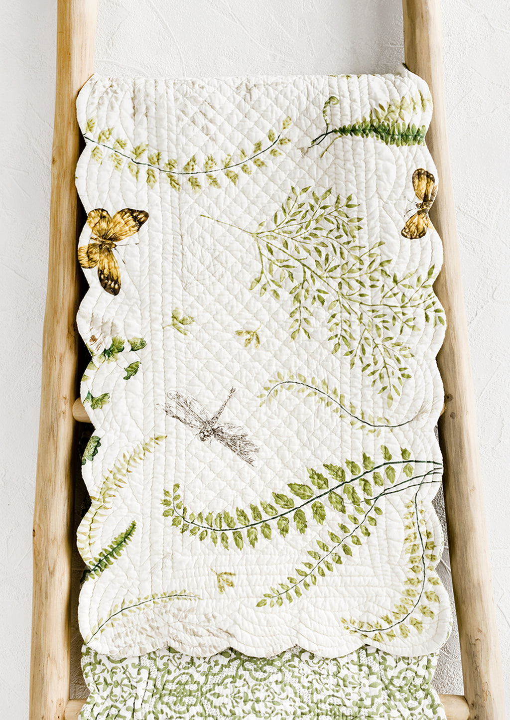 1: A quilted table runner with fern print.