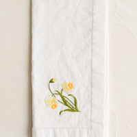 Daffodil: A white cotton napkin with daffodil embroidery.