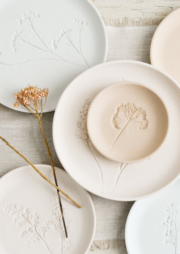 Small / Sand: Stacked pastel porcelain plates with plant imprint designs.
