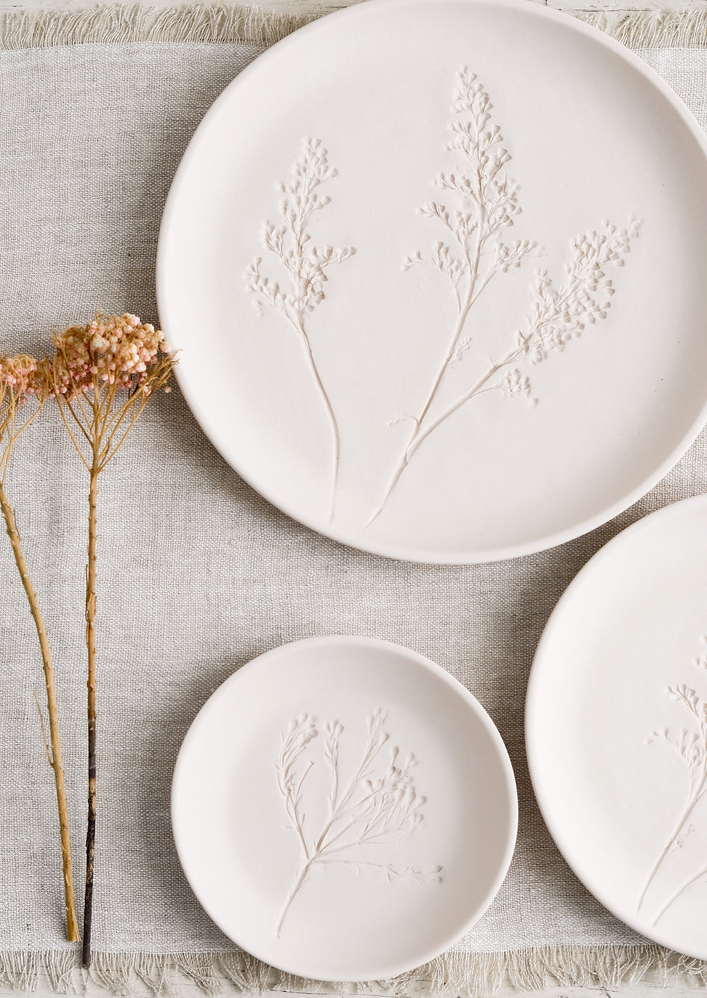 Small / Blush: Stacked pastel porcelain plates with plant imprint designs.