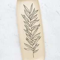 Willow: A long and skinny ceramic tray in natural bisque color with an etched black drawing of a Willow plant.