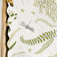 2: A quilted table runner with fern print.