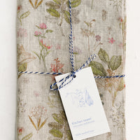 Natural Multi: A botanically printed natural linen tea towel, folded and tagged.