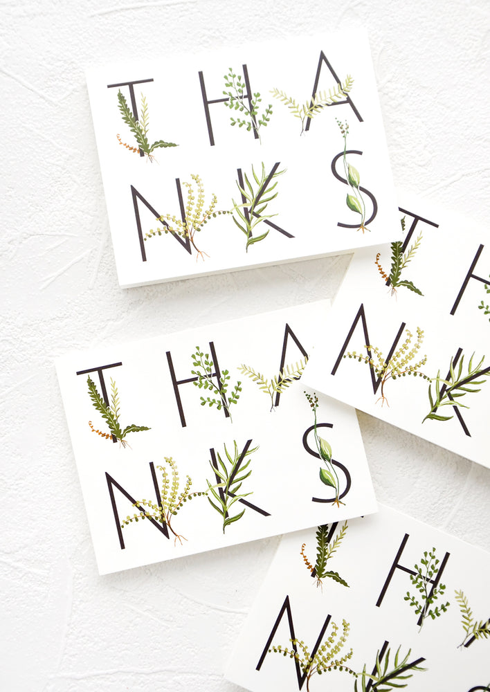 Multiple greeting cards in same design, spelling "THANKS" in capital letters wrapped with greenery