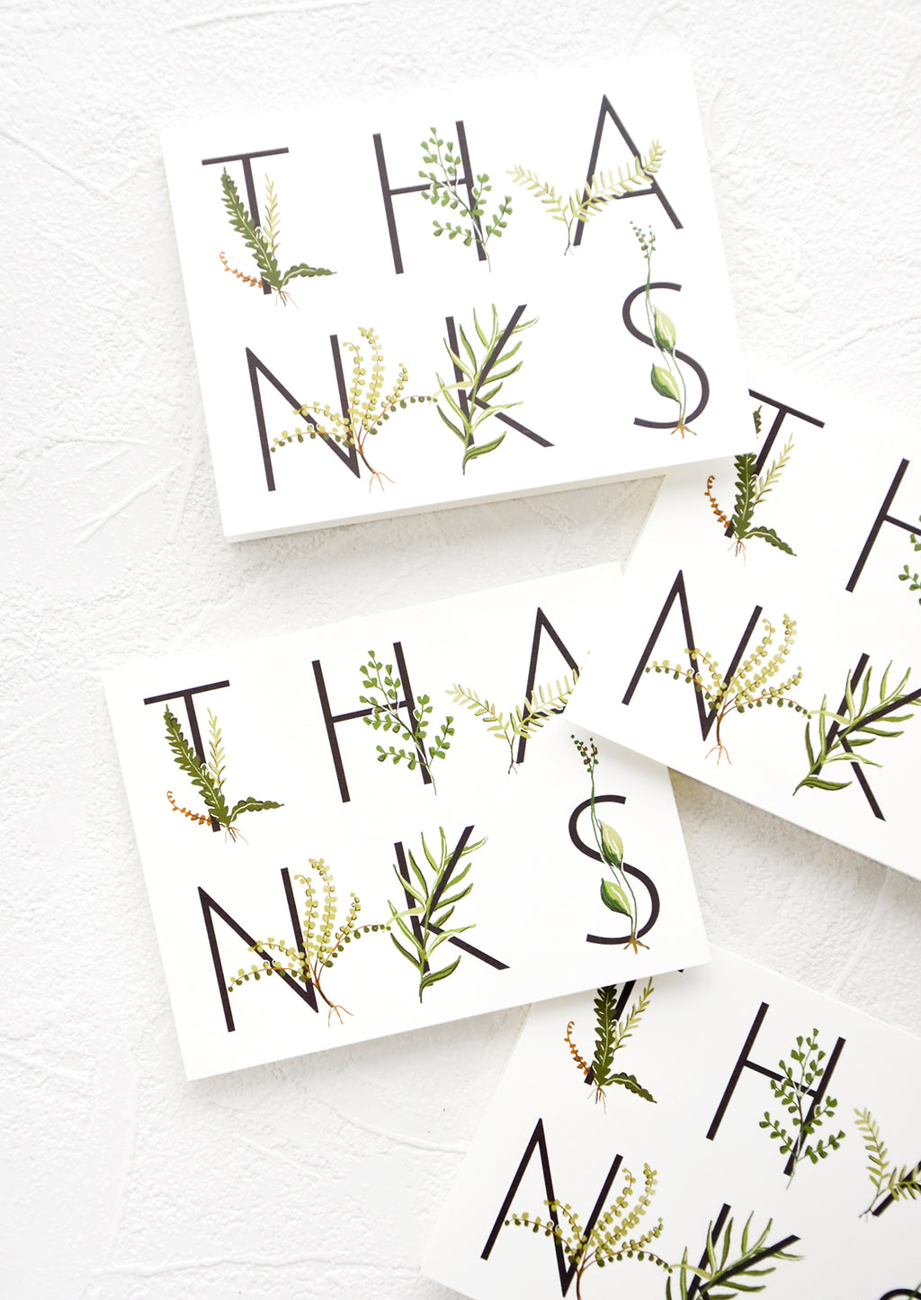 1: Multiple greeting cards in same design, spelling "THANKS" in capital letters wrapped with greenery