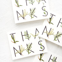 1: Multiple greeting cards in same design, spelling "THANKS" in capital letters wrapped with greenery